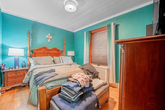 bedroom with crown molding and light hardwood / wood-style flooring