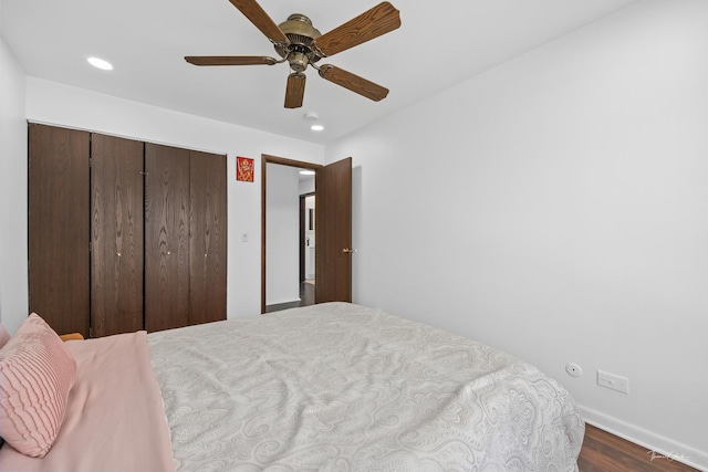 bedroom featuring ceiling fan, a closet, and hardwood / wood-style floors