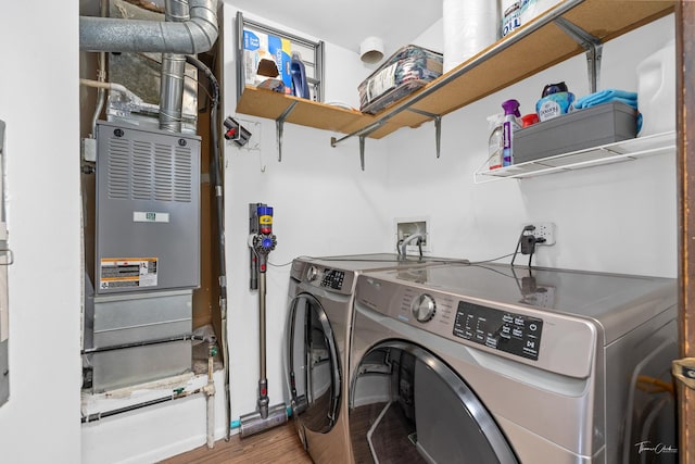 washroom with washing machine and dryer and hardwood / wood-style flooring