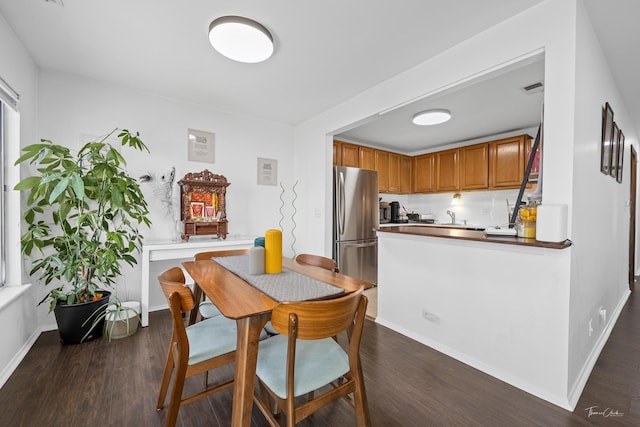 dining space featuring dark wood-type flooring and sink