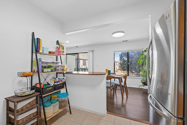 kitchen with stainless steel fridge and light tile patterned flooring