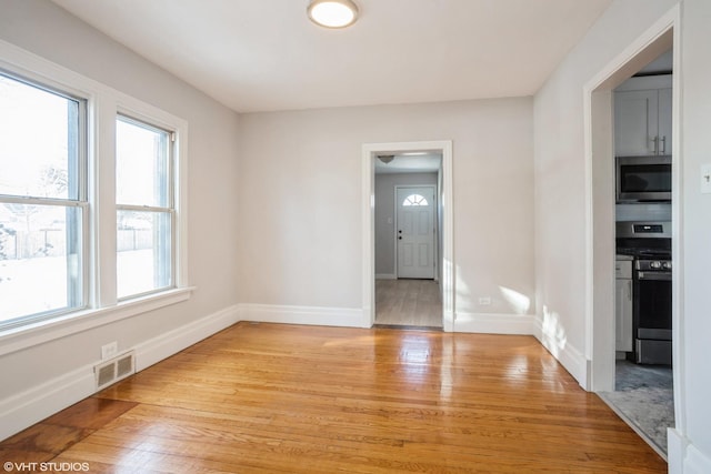 unfurnished room with light wood-type flooring