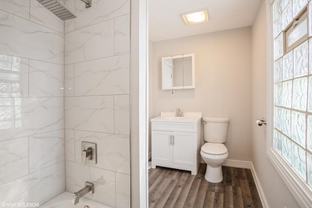 full bathroom featuring toilet, tiled shower / bath, hardwood / wood-style flooring, and vanity