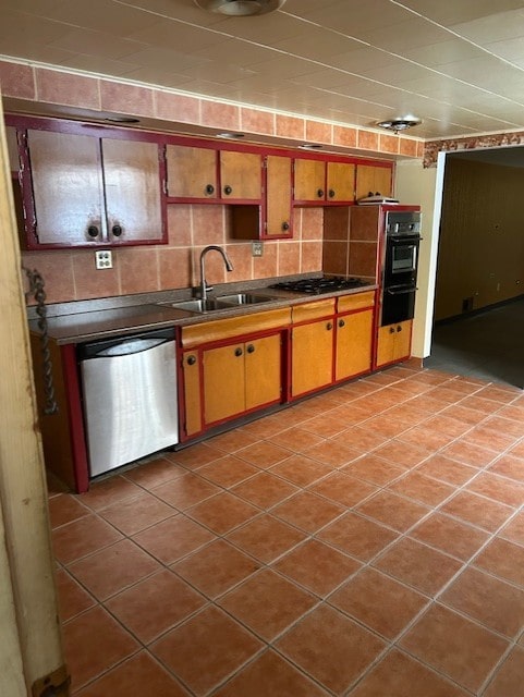 kitchen with light tile patterned floors, stainless steel appliances, decorative backsplash, and sink