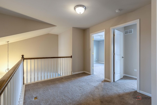 hall with vaulted ceiling and carpet flooring