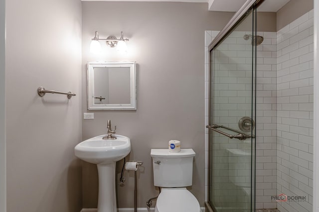 bathroom with a shower with door and toilet