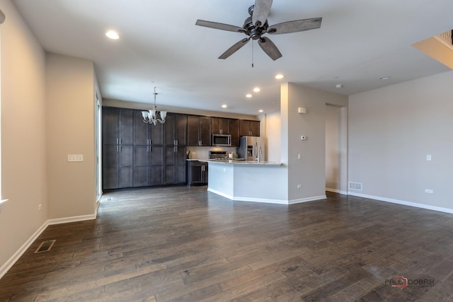 unfurnished living room with dark wood-type flooring and ceiling fan with notable chandelier