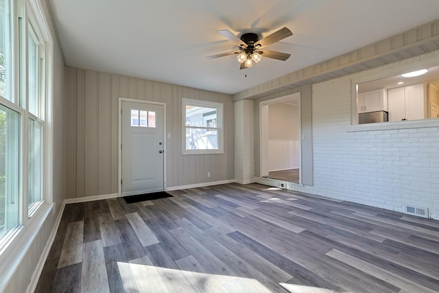 foyer featuring ceiling fan, brick wall, and hardwood / wood-style flooring