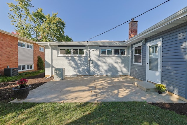 rear view of property featuring central AC, a yard, and a patio