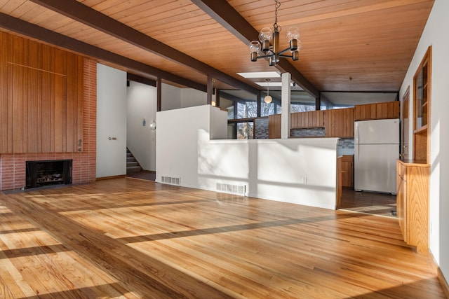 interior space featuring vaulted ceiling with beams, a fireplace, light hardwood / wood-style floors, and wood ceiling