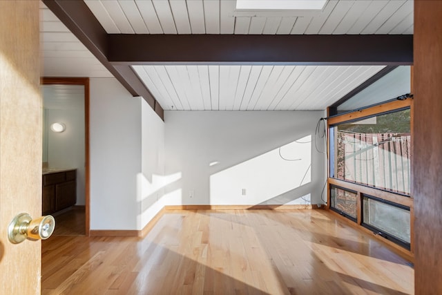 interior space with lofted ceiling with beams and light wood-type flooring