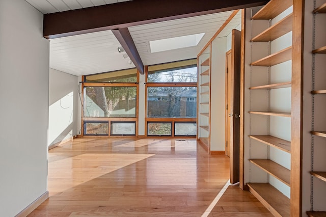 interior space featuring vaulted ceiling with beams, hardwood / wood-style flooring, and a wall of windows