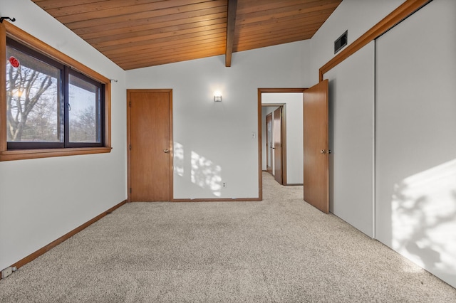 unfurnished bedroom featuring a closet, lofted ceiling with beams, light carpet, and wooden ceiling