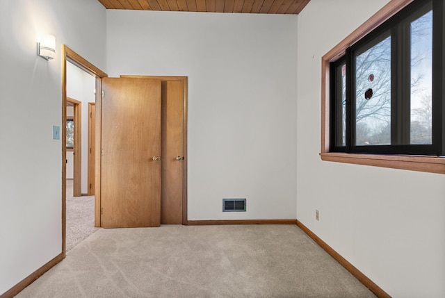 unfurnished bedroom featuring wood ceiling and light colored carpet