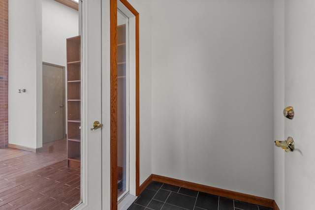 hallway featuring dark tile patterned floors