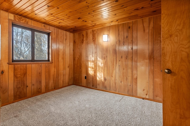 unfurnished room with wood ceiling, wooden walls, and carpet