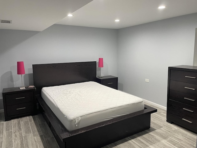 bedroom with wood finish floors, recessed lighting, visible vents, and baseboards