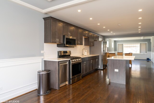 dining room featuring ornamental molding, coffered ceiling, dark wood finished floors, and a wealth of natural light