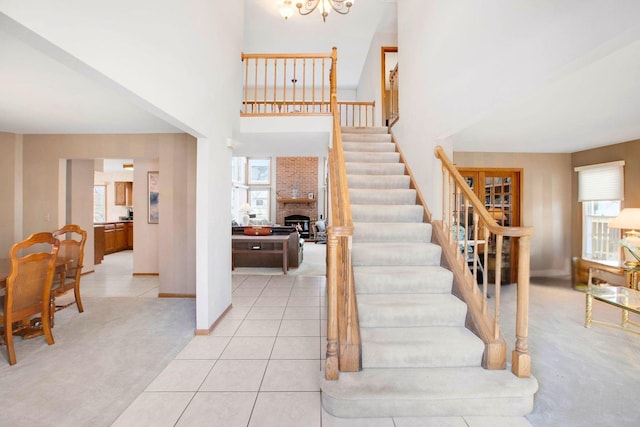 stairs featuring a chandelier, carpet floors, plenty of natural light, and tile patterned flooring