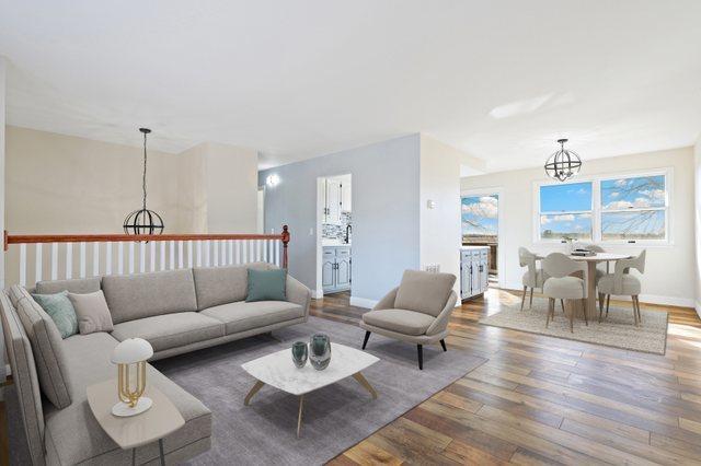 living room featuring an inviting chandelier and dark wood-type flooring