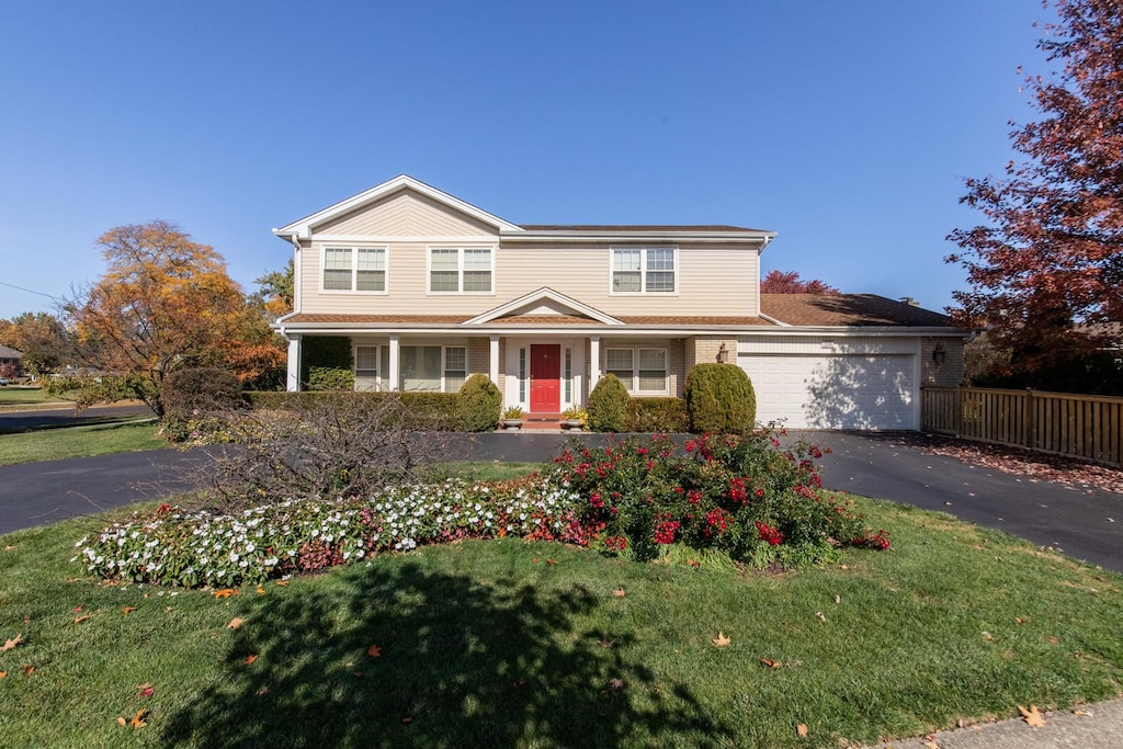 view of property featuring a garage and a front yard