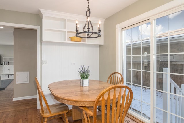 dining area with wood-type flooring and an inviting chandelier