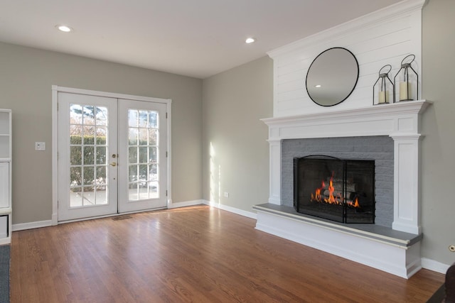 unfurnished living room with hardwood / wood-style flooring, a fireplace, and french doors