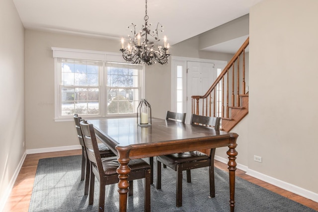 dining area featuring wood-type flooring and an inviting chandelier