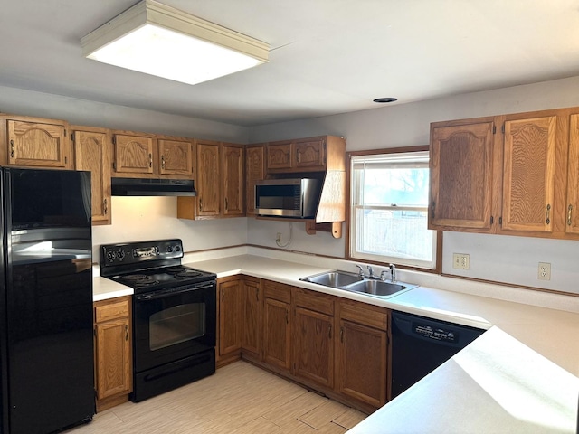 kitchen with sink, black appliances, and light wood-type flooring