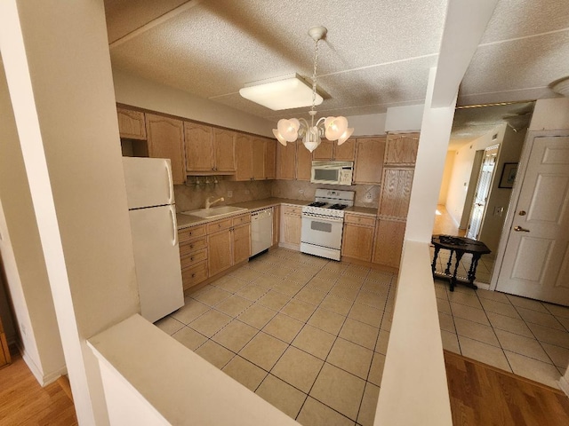 kitchen with sink, white appliances, light tile patterned floors, and tasteful backsplash