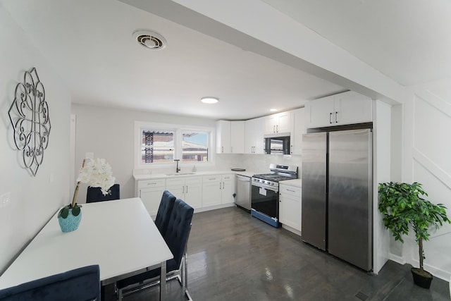 kitchen with sink, white cabinetry, stainless steel appliances, and tasteful backsplash