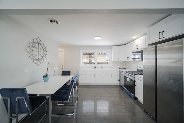 kitchen featuring decorative backsplash, sink, white cabinetry, and stainless steel appliances