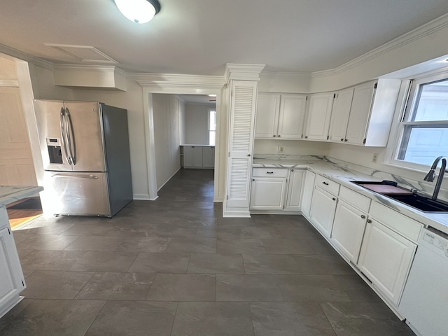 kitchen featuring sink, white cabinets, stainless steel fridge, and white dishwasher