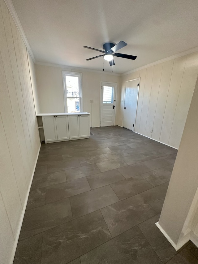 empty room with ceiling fan and ornamental molding