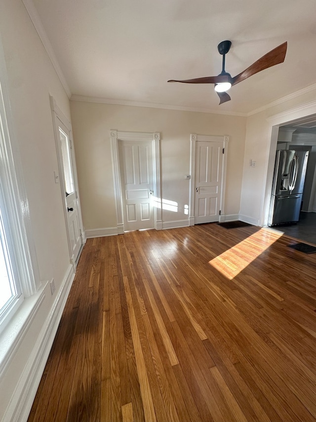 foyer entrance with hardwood / wood-style flooring, ornamental molding, and ceiling fan