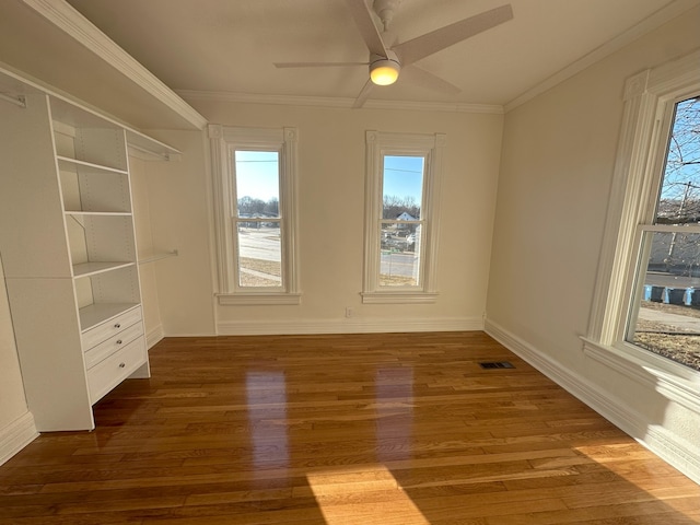 unfurnished room with ceiling fan, crown molding, and wood-type flooring