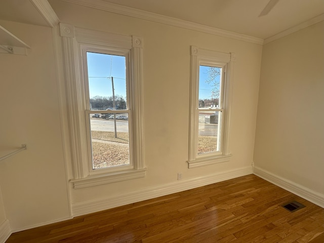 unfurnished room with crown molding and dark wood-type flooring