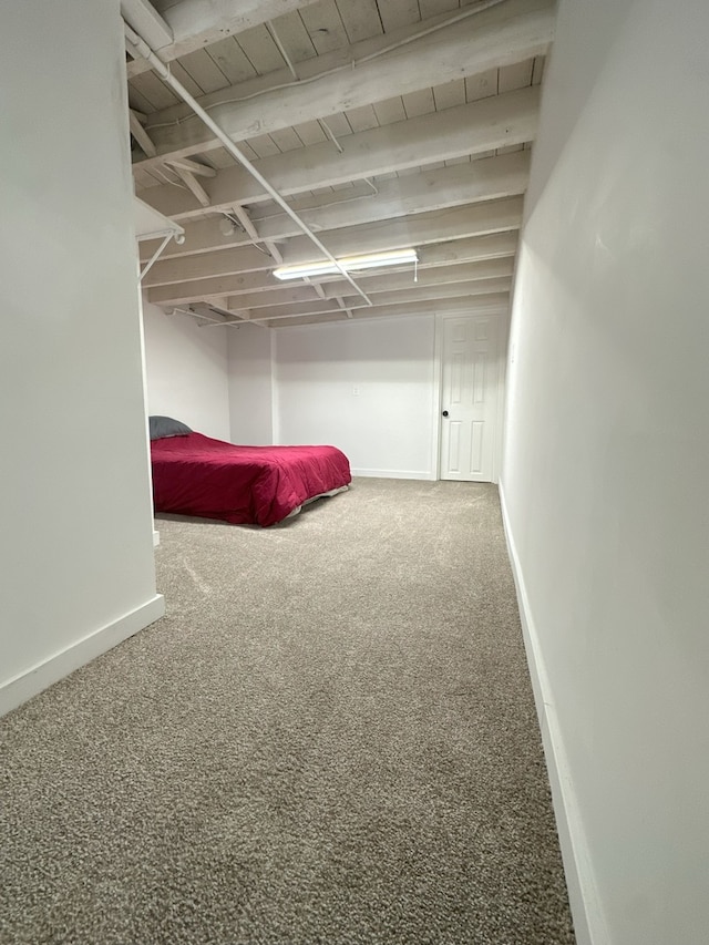 unfurnished bedroom featuring wooden ceiling, beam ceiling, and carpet floors