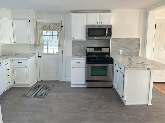 kitchen featuring kitchen peninsula, white cabinetry, light stone counters, decorative backsplash, and stainless steel appliances