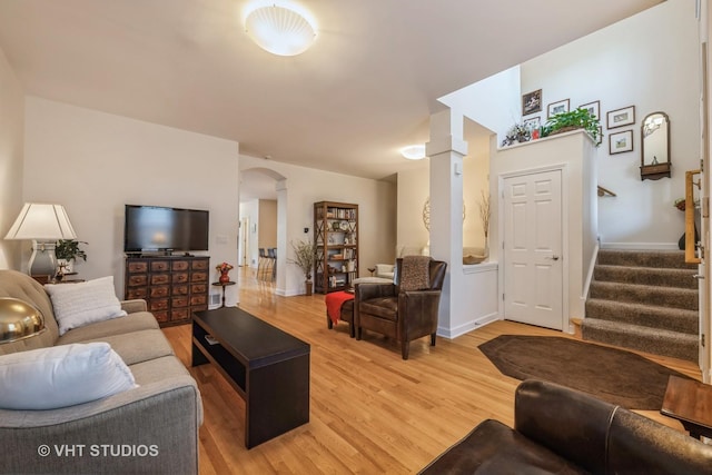 living room with wood-type flooring and ornate columns