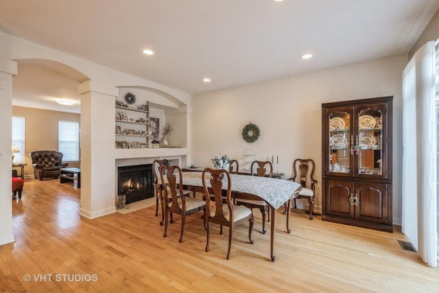 dining room featuring built in features and light hardwood / wood-style floors