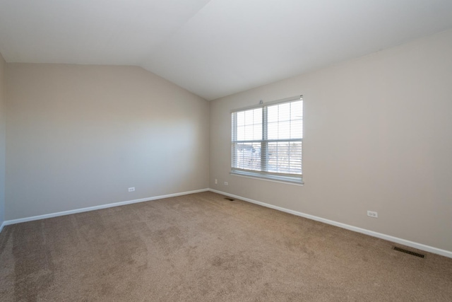 carpeted empty room with lofted ceiling