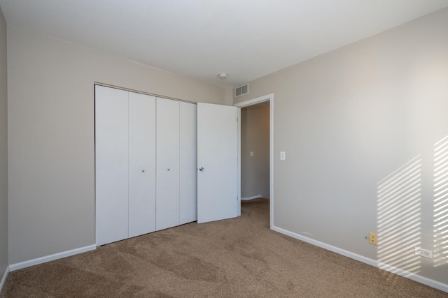 unfurnished bedroom featuring a closet and light carpet