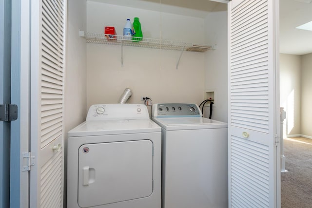 clothes washing area with washer and clothes dryer and carpet flooring