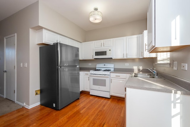 kitchen featuring white appliances, white cabinets, light hardwood / wood-style floors, and sink