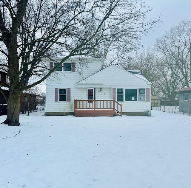 snow covered rear of property featuring a deck