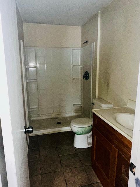 bathroom with toilet, vanity, and walk in shower