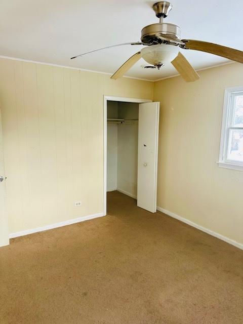 unfurnished bedroom with ceiling fan, a closet, and carpet floors