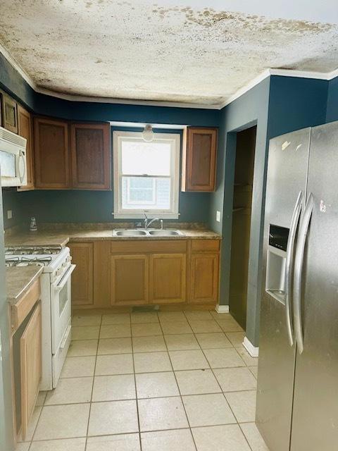 kitchen with light tile patterned floors, ornamental molding, sink, and white appliances