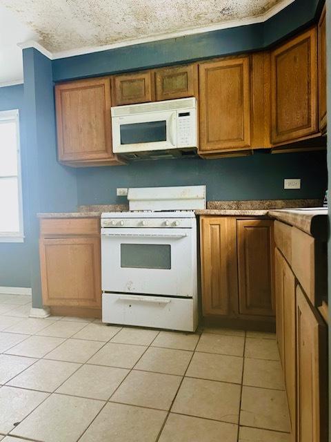 22012 Millard Ave, Richton Park, IL 60471 - kitchen featuring a sink, light tile patterned floors, white appliances, and ornamental molding